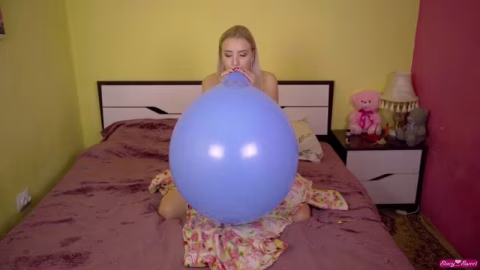 A Beautiful Blonde Girl Inflates Balloons